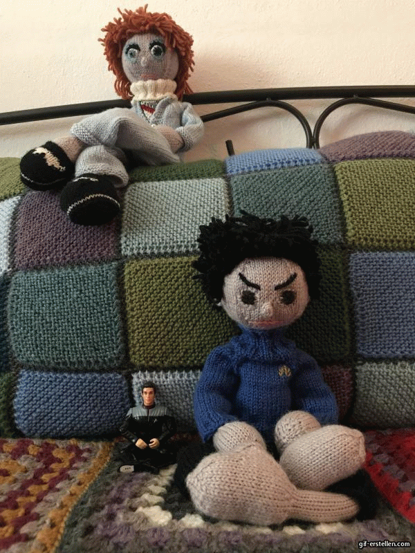 A gif made of three images. I shows a knitted doll of David Bowie sitting atop a knitted cushion. In front of the cushion sits a knitted doll of Spock. Next to him an action figure of Capt. Calhoun. Spock turns his head up to Bowie, then Bowie turns his head down to Spock.